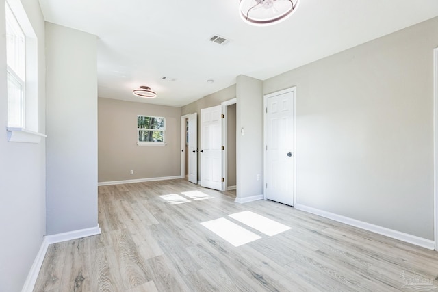 empty room featuring light wood finished floors and baseboards