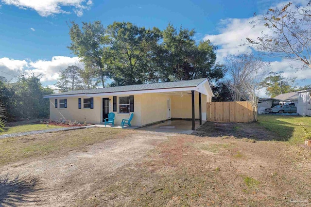 view of front of house featuring dirt driveway and a carport