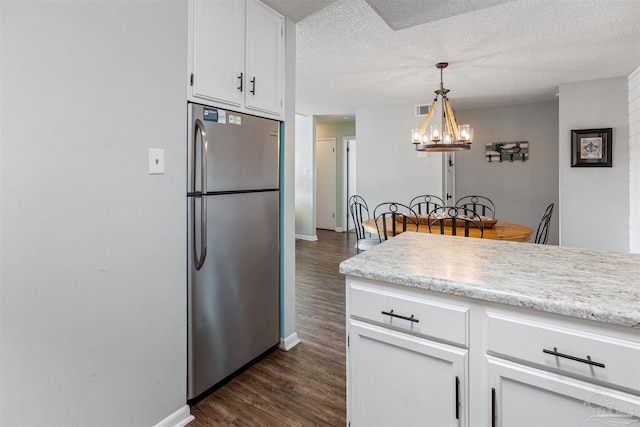 kitchen featuring white cabinetry, light countertops, freestanding refrigerator, and dark wood-style flooring