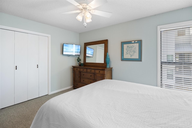 carpeted bedroom featuring a closet, baseboards, a textured ceiling, and a ceiling fan