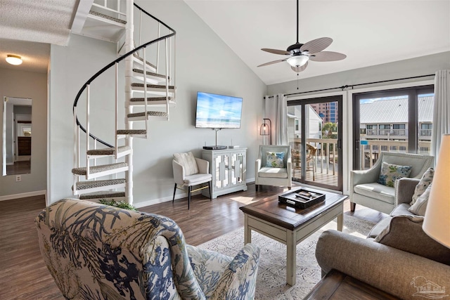 living room featuring a ceiling fan, wood finished floors, stairway, baseboards, and vaulted ceiling