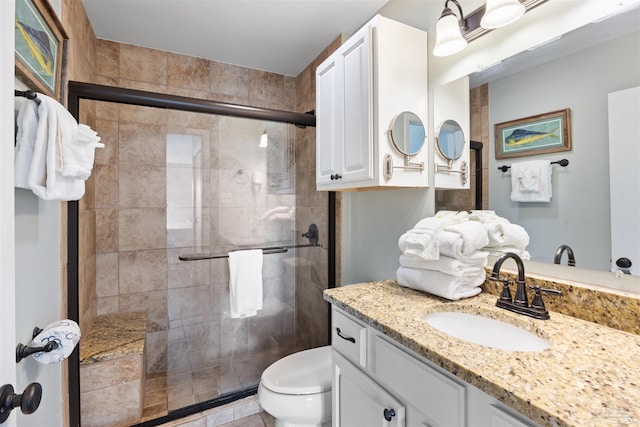 bathroom with vanity, toilet, and a stall shower