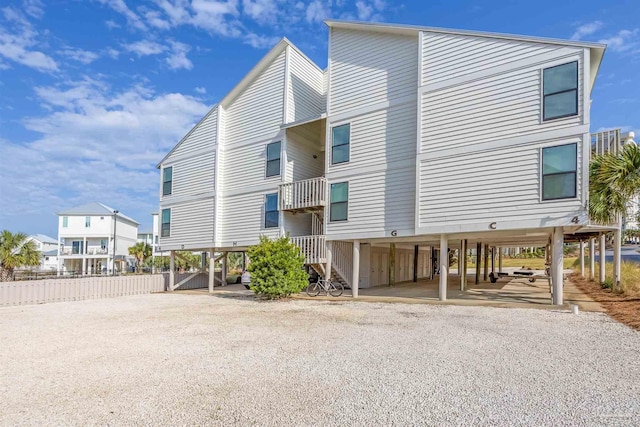 exterior space with a carport, driveway, and stairs