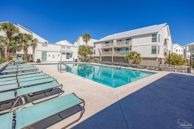 community pool with a patio area and a residential view