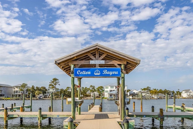 view of dock with boat lift, a residential view, and a water view