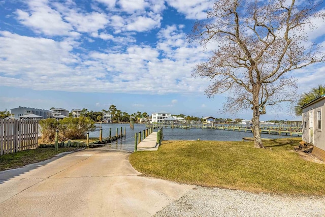 exterior space featuring a lawn, fence, and a water view