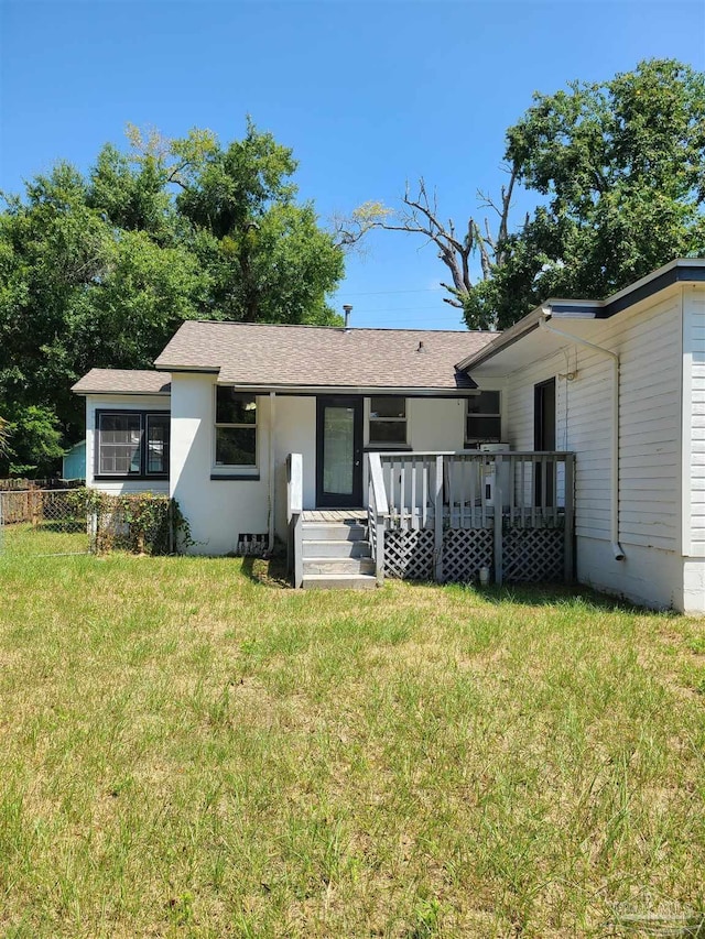 rear view of property featuring a lawn