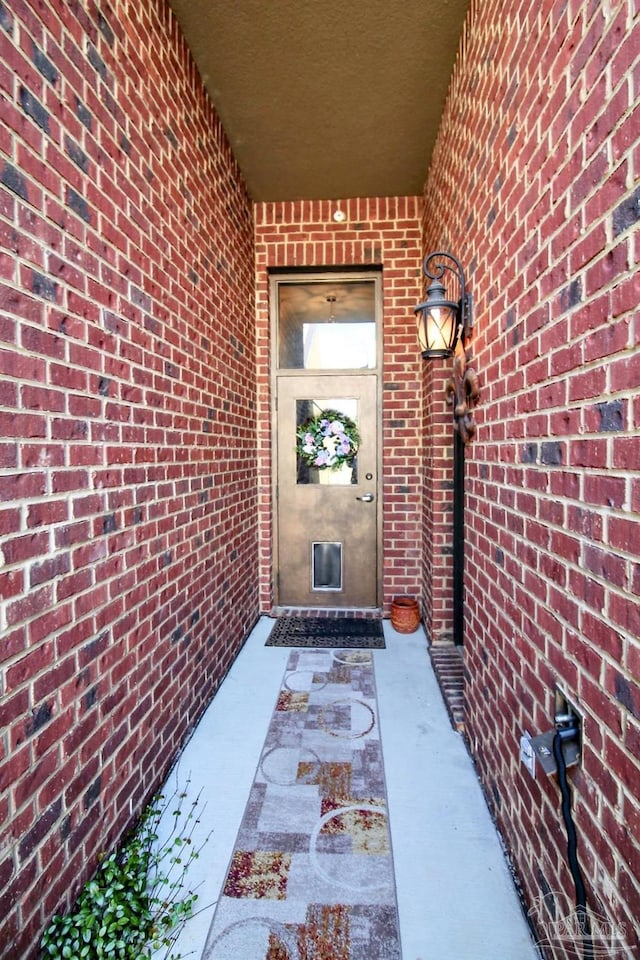 entrance to property featuring brick siding