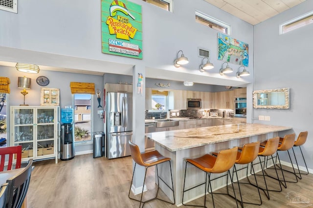 1112 Maldonado Dr, Pensacola Beach, FL 32561 - kitchen with a kitchen bar, kitchen peninsula, a wealth of natural light, and stainless steel appliances