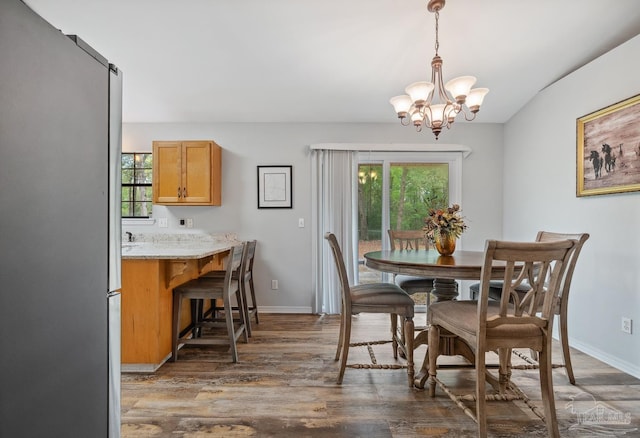 dining room with baseboards, wood finished floors, and a chandelier