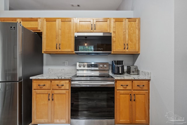 kitchen featuring light stone countertops, stainless steel appliances, and visible vents