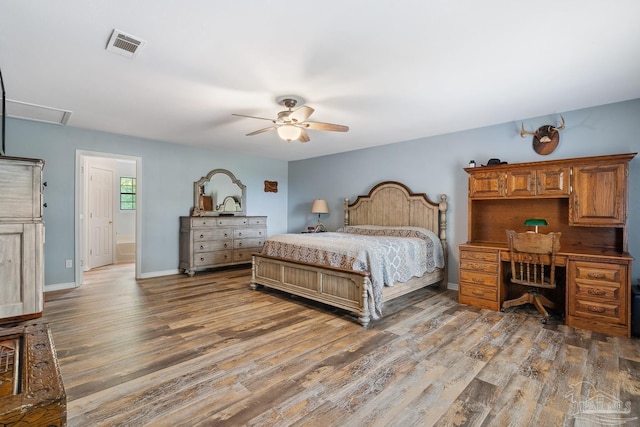 bedroom featuring baseboards, visible vents, a ceiling fan, and wood finished floors