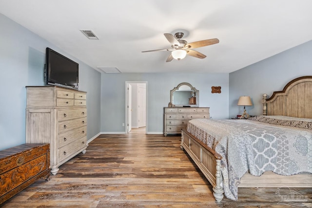 bedroom featuring baseboards, ceiling fan, visible vents, and wood finished floors
