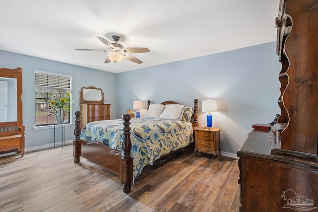 bedroom with baseboards, wood finished floors, and a ceiling fan
