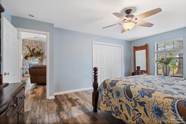 bedroom with baseboards, dark wood-style floors, a closet, and ceiling fan