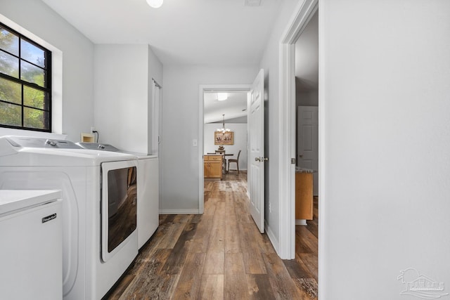 laundry room with dark wood-style flooring, washing machine and dryer, baseboards, and laundry area