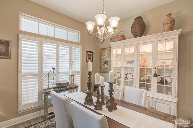 dining space featuring a notable chandelier and light wood-type flooring