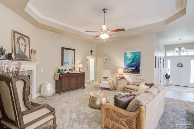 living room with light colored carpet, ornamental molding, and a raised ceiling