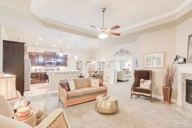 living room with carpet flooring, ornamental molding, ceiling fan, a raised ceiling, and a textured ceiling