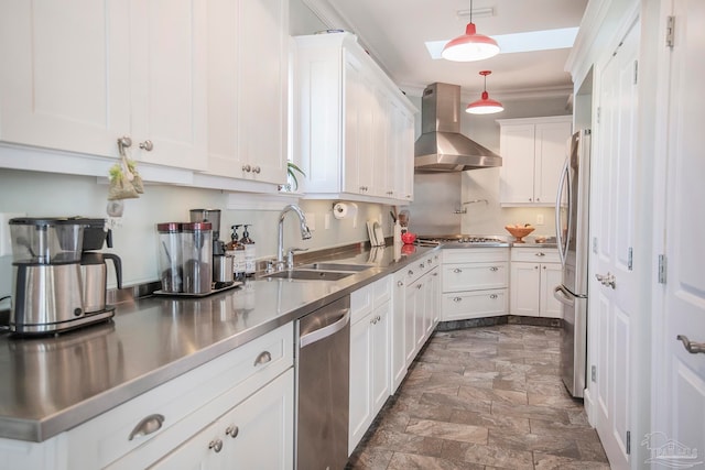 kitchen featuring wall chimney exhaust hood, white cabinets, sink, and stainless steel counters