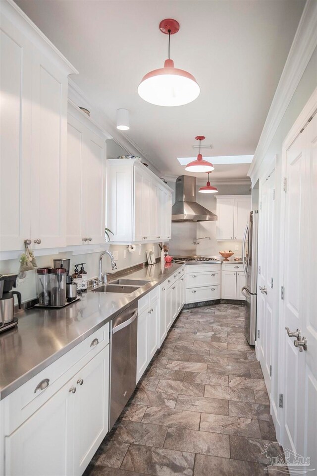 kitchen with white cabinetry, wall chimney range hood, and stainless steel counters