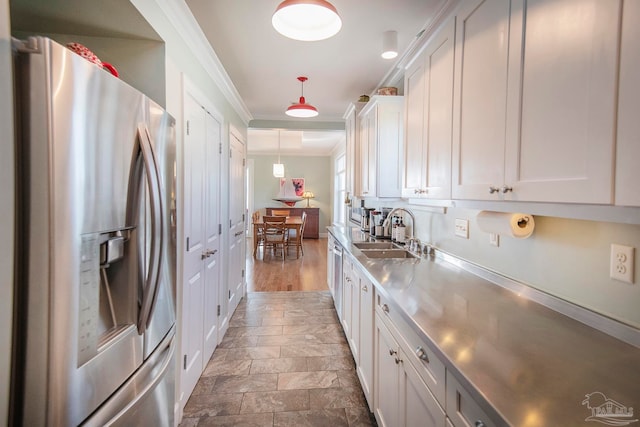 kitchen featuring sink, white cabinetry, stainless steel refrigerator with ice dispenser, and stainless steel counters