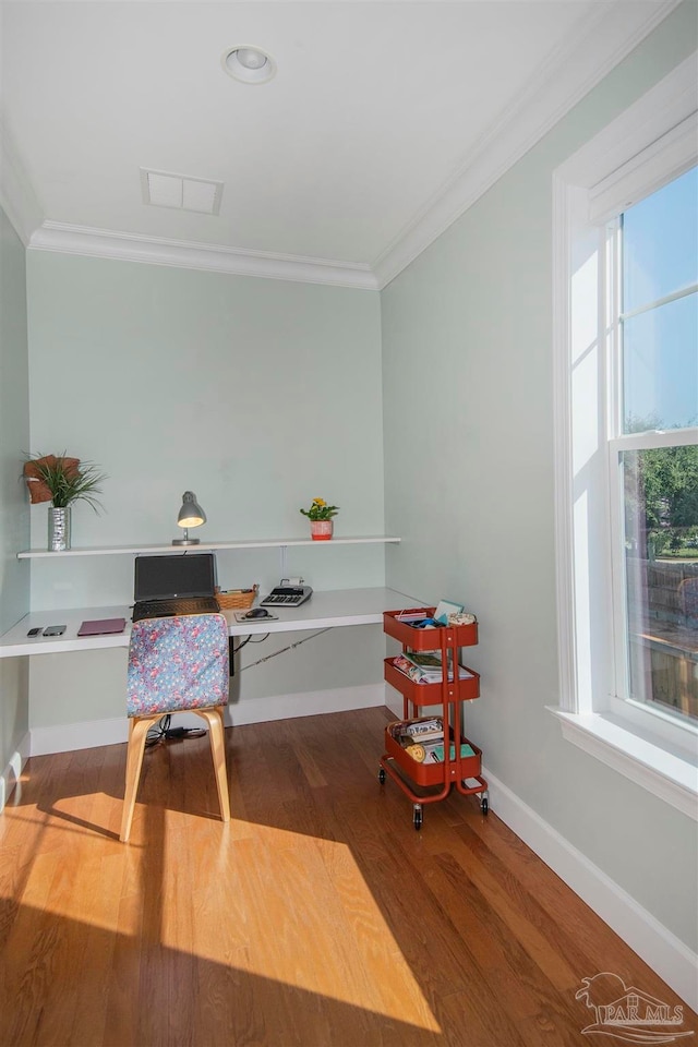 home office with crown molding, hardwood / wood-style floors, and built in desk