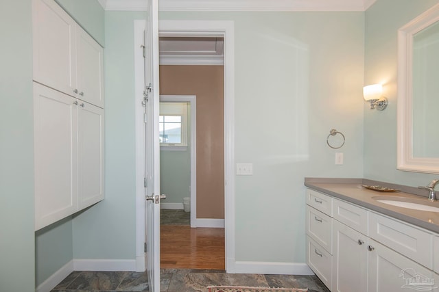 bathroom with vanity, ornamental molding, and hardwood / wood-style flooring