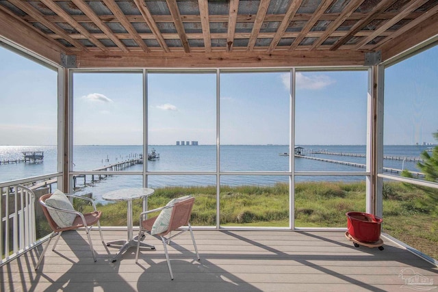 unfurnished sunroom featuring a water view