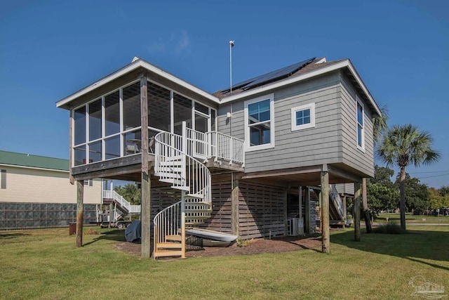 back of house with solar panels, a lawn, and a sunroom