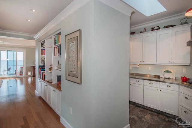 hall featuring ornamental molding, a skylight, and dark hardwood / wood-style floors