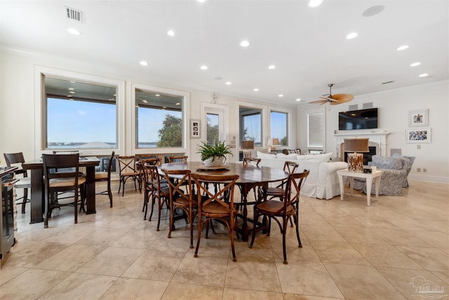 dining room featuring ceiling fan, light tile patterned flooring, and crown molding