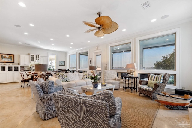 tiled living room featuring ornamental molding and ceiling fan