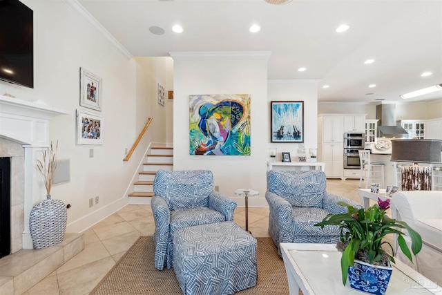 living room featuring light tile patterned flooring, a tiled fireplace, and ornamental molding