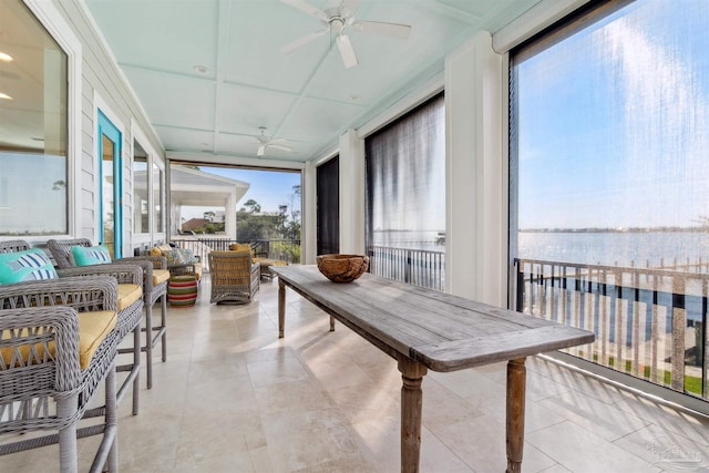 sunroom featuring a water view and ceiling fan