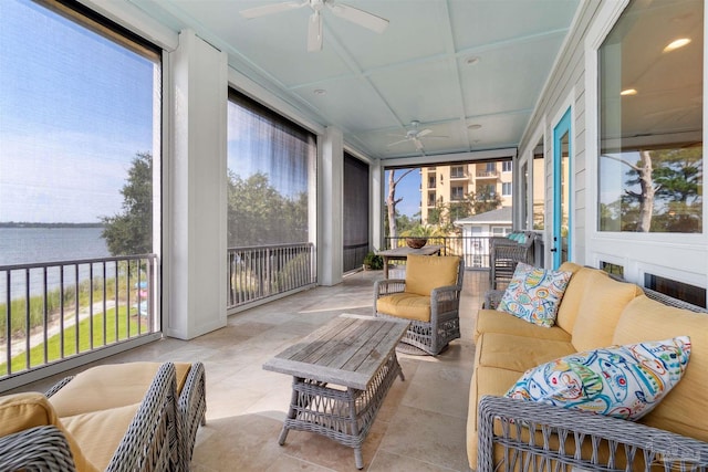 sunroom / solarium with a water view, ceiling fan, and a wealth of natural light