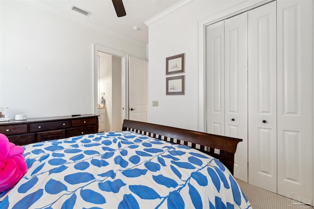 carpeted bedroom featuring ornamental molding, ceiling fan, and a closet