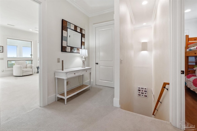 hallway with ornamental molding and light colored carpet