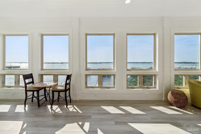 sunroom / solarium with a water view and a healthy amount of sunlight