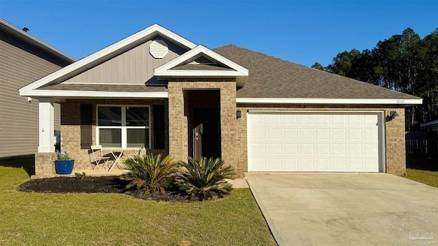 view of front facade featuring driveway, a shingled roof, an attached garage, and a front yard