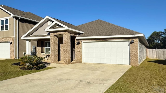 view of front of house featuring a garage, concrete driveway, fence, a front yard, and brick siding