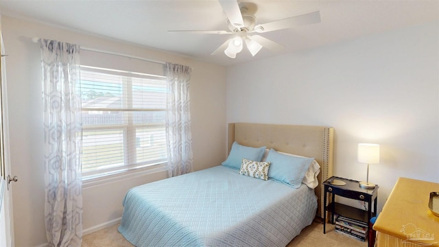 bedroom with multiple windows, baseboards, a ceiling fan, and light colored carpet