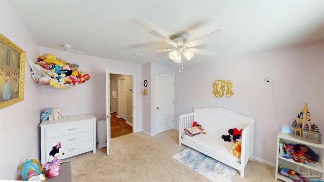 recreation room featuring a ceiling fan, light colored carpet, and baseboards