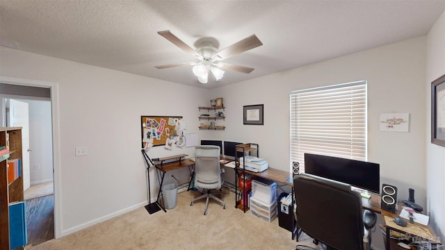 office area with light carpet, a textured ceiling, baseboards, and a ceiling fan