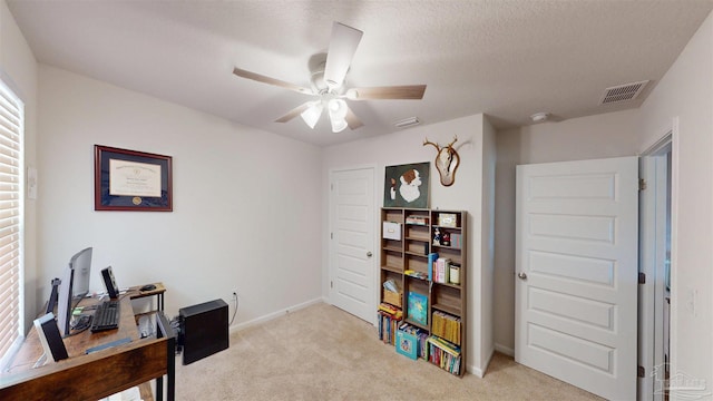 office space with ceiling fan, baseboards, visible vents, and light colored carpet