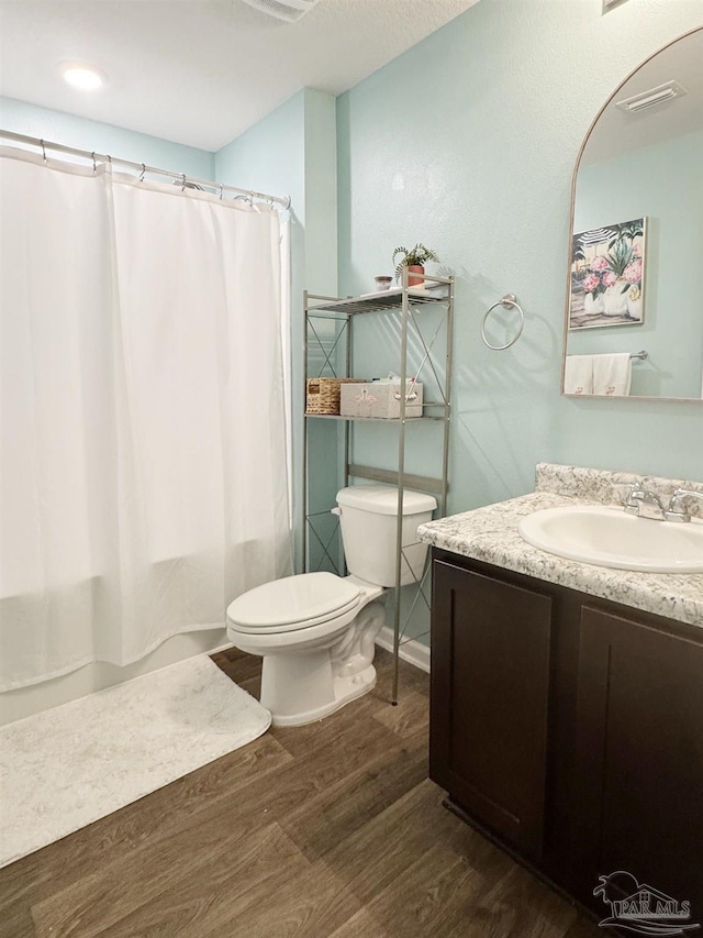 full bathroom with toilet, shower / bath combination with curtain, wood finished floors, and vanity