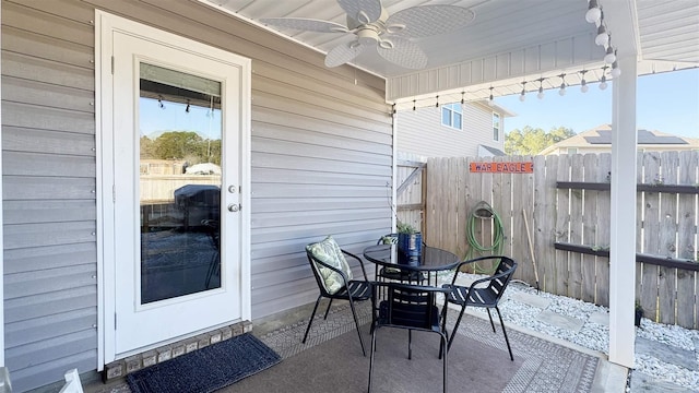 view of patio featuring outdoor dining area, fence, and ceiling fan