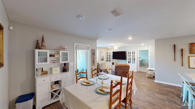 dining area featuring visible vents, baseboards, and wood finished floors