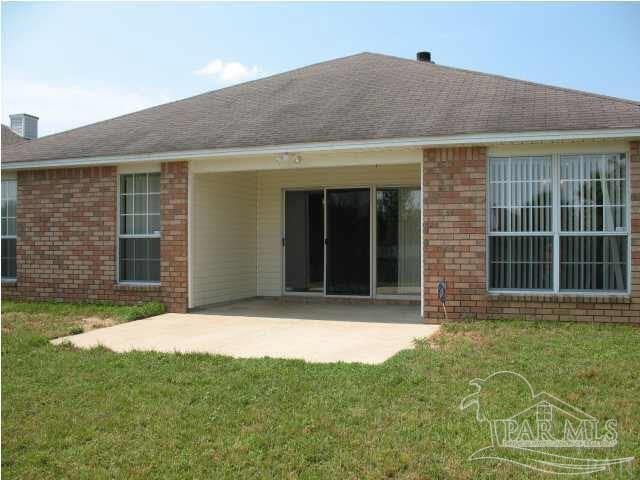 back of property with a patio area and a yard