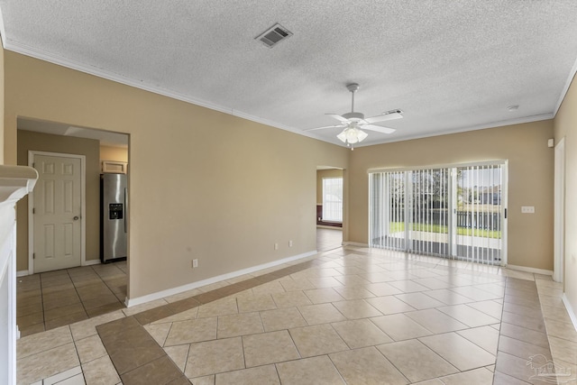 spare room featuring a textured ceiling, ceiling fan, light tile patterned floors, and ornamental molding